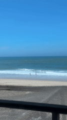 Two beachgoers enjoy sunny afternoon at Portuguese coastline