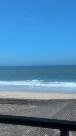 Two beachgoers enjoy sunny afternoon at Portuguese coastline