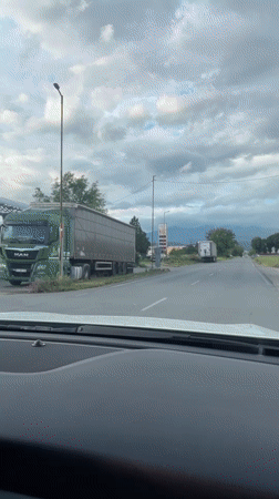 Mercedes drives past trucks and gas station in Blagoevgrad