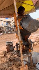 Man operates gasoline grinder under umbrella in Nigeria