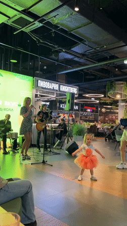 Live band rocks a small indoor venue under green stage lights