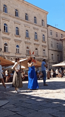 Afternoon activity in a sun-lit European stone plaza