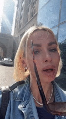 Woman puts on sunglasses on Dubai street