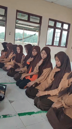 Students perform synchronized dance routine in Indonesian classroom