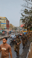 Morning street life documented across Dhaka neighborhoods includes military patrol
