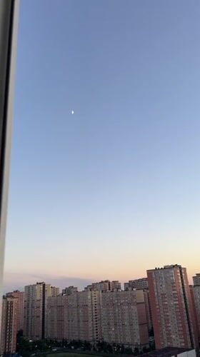 Krasnodar skyline at sunset with a crescent moon rising