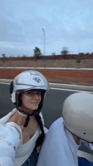 Couple rides motor scooter through Phan Thiết, Vietnam