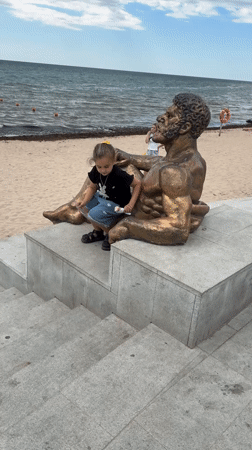 Summer morning at Yevpatoriya's beach promenade with ice cream and statues