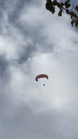 Paragliders soar over scenic Fethiye coastline under cloudy skies