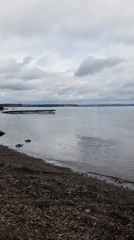 Calm lakeside scene with dock and domed church, Chastyye