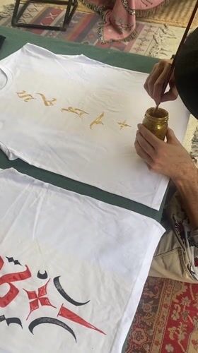 Artist hand-paints ornate designs on t-shirts in Thailand