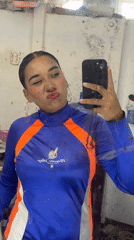 Person takes selfies in blue-orange outfit in Porlamar