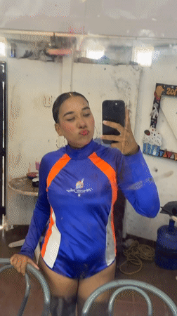 Person takes selfies in blue-orange outfit in Porlamar
