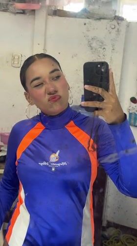 Person takes selfies in blue-orange outfit in Porlamar