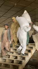 Workers Load White Sacks at Kandahar Warehouse Facility