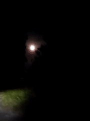 Nighttime motorcycle ride captured under full moon in Lhokseumawe