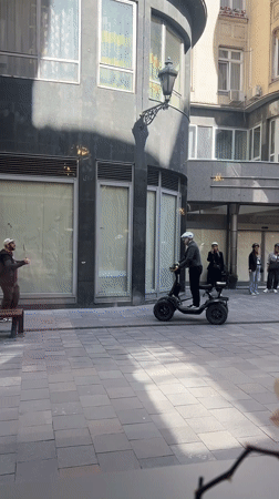 Man rides three-wheeled scooter in Budapest courtyard