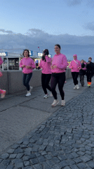 Women in pink workout gear run cobblestone path in Saint Petersburg