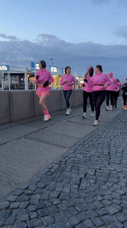 Women in pink workout gear run cobblestone path in Saint Petersburg