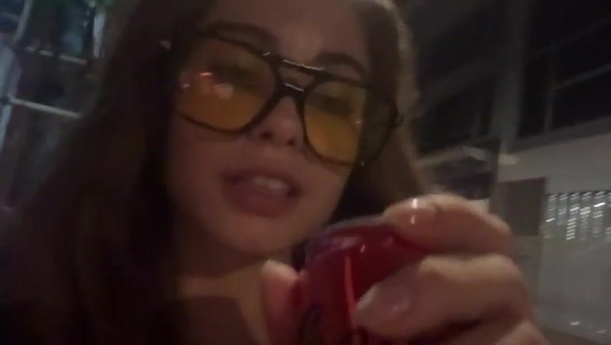Woman drinks soda from red can in Hong Kong