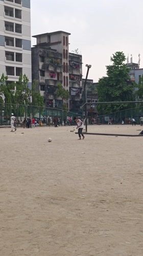 Children play soccer and cricket in Dhaka field