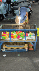 Vendor sells dyed chicks from cart in Tabanan, Indonesia