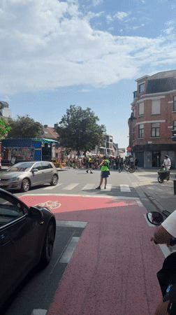 Traffic controller directs vehicles on bicycle crosswalk in Ghent