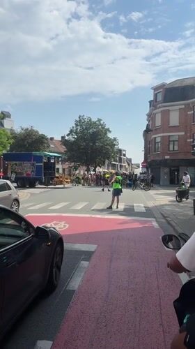 Traffic controller directs vehicles on bicycle crosswalk in Ghent