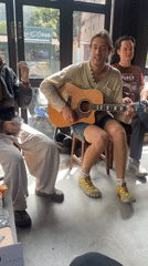Informal acoustic music session among four people in Pokhara cafe