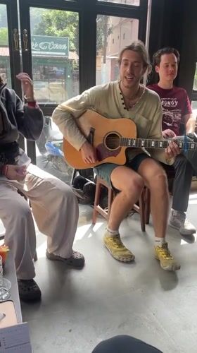 Informal acoustic music session among four people in Pokhara cafe