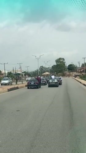 Woman stands on Mercedes roof during motorcade in Nigeria