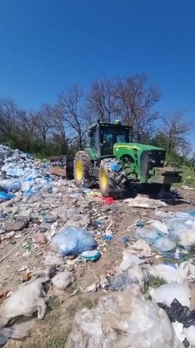 Tractor sits among trash pile in Bulgarian countryside