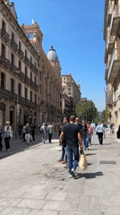Barcelona plaza fountain area draws pigeons, pedestrians during sunny afternoon