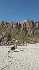 Sunny beach day at Carnboy with caravans, cliffs, and calm water