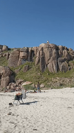 Sunny beach day at Carnboy with caravans, cliffs, and calm water
