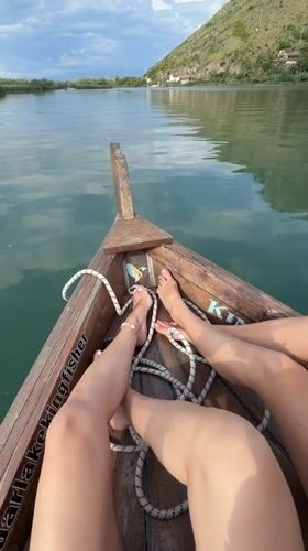 Women relax on wooden boat during lake outing in Montenegro