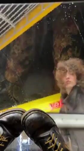 Person cleans yellow vehicle window with squeegee in Haifa