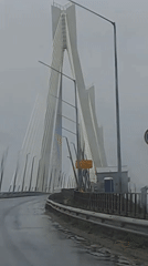 Vehicle crosses cable-stayed bridge during heavy rain in Russia