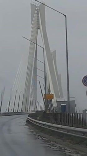 Vehicle crosses cable-stayed bridge during heavy rain in Russia