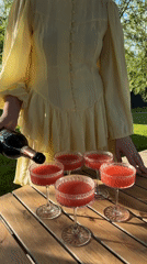 Woman serves drinks at outdoor gathering in Dobroe, Russia