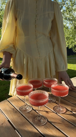 Woman serves drinks at outdoor gathering in Dobroe, Russia