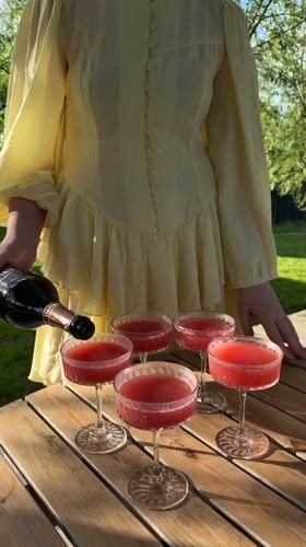 Woman serves drinks at outdoor gathering in Dobroe, Russia