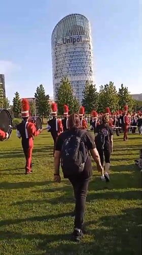 Marching band rehearses in Milan's Porta Nuova park on a summer afternoon
