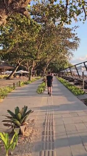 Sunset hour along Sanur Beach's shore and promenade