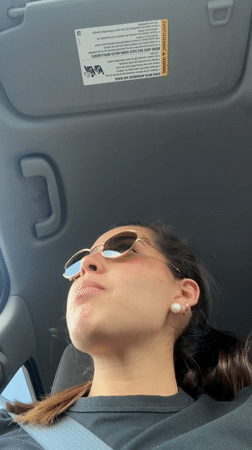 Woman in sunglasses looks up while sitting in car