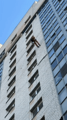 Person in red jumpsuit rappels down building in Saint Petersburg