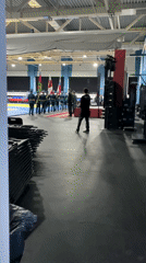 Military band performs in formation at indoor arena