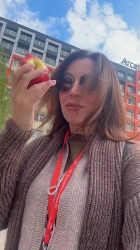 Woman eats apple outdoors in Kryvyi Rih, Ukraine