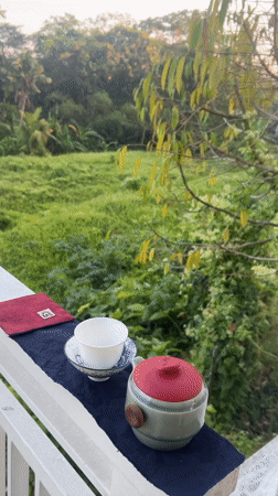 Tea on a balcony rail overlooking green hills in Kediri