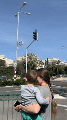 Woman and child wait at crosswalk in Kiryat Motzkin